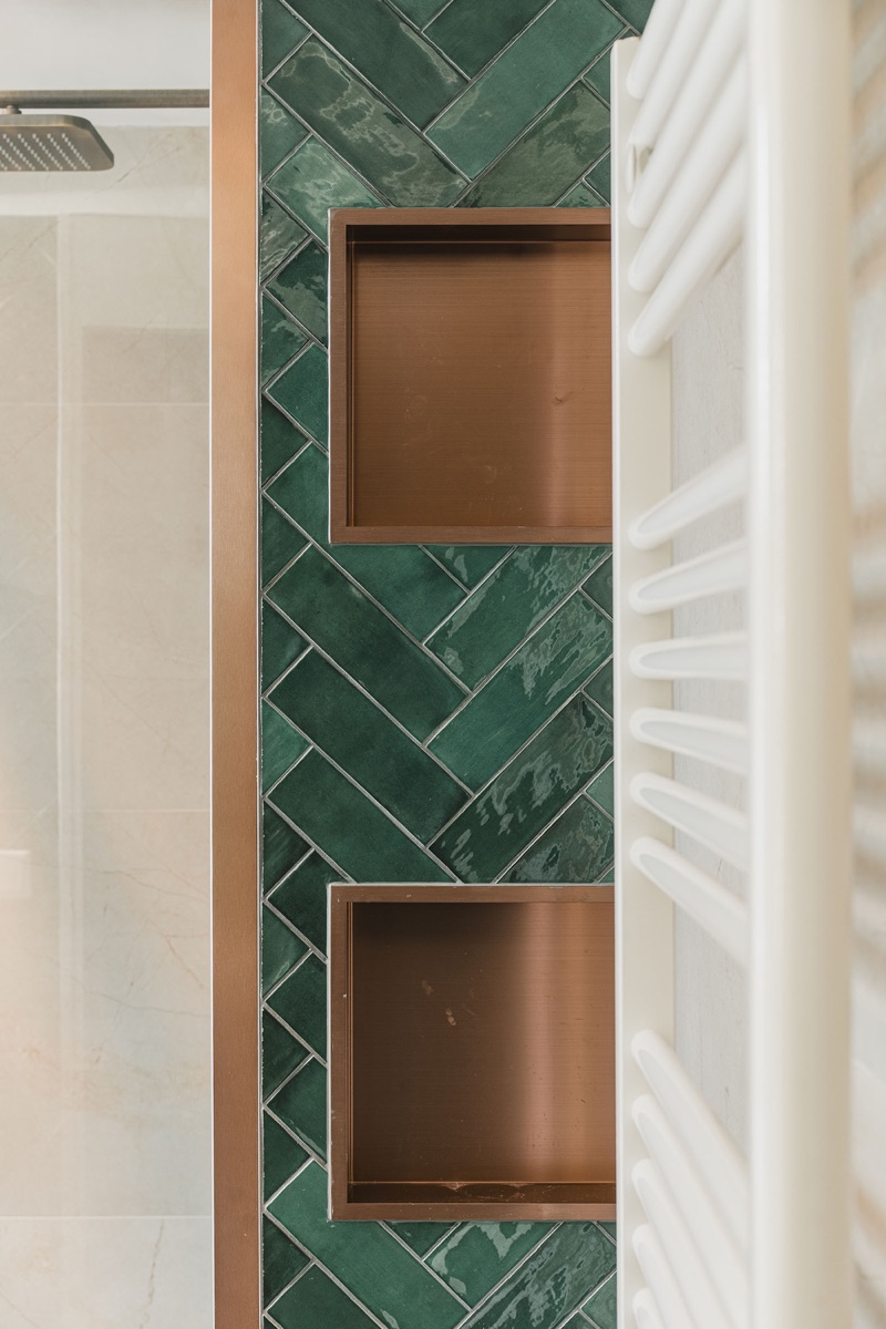Luxe badkamer met groen visgraatpatroon en koperen accenten