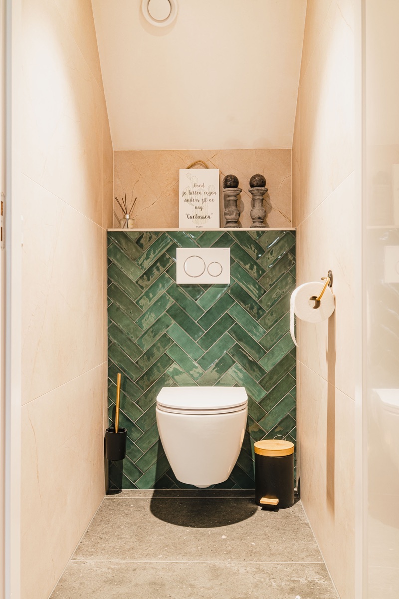 Tegelwerk met groen visgraatpatroon, detail toiletruimte