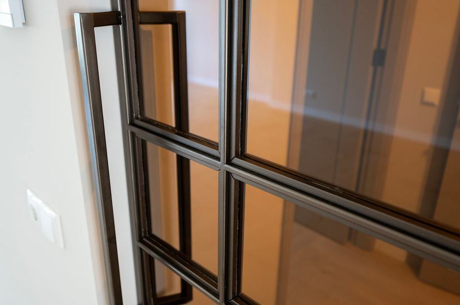 Detail van het zwarte stalen deurprofiel en glas