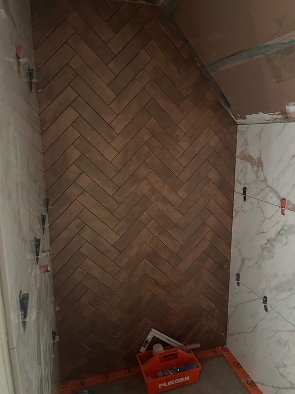 Visgraatpatroon in terracotta tijdens het leggen